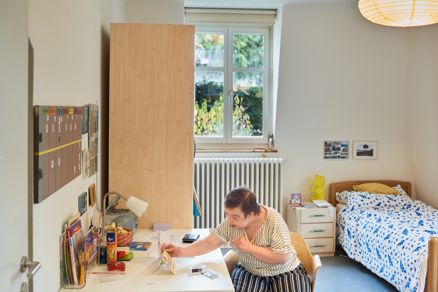 Bewohnerin beim Basteln in einem schönen Zimmer an der Friedensgasse
